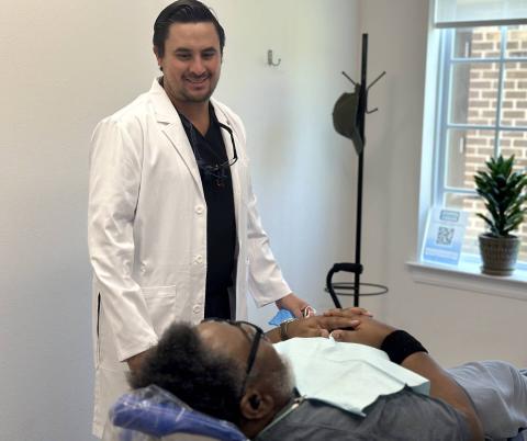 Dr. Galindo speaking with a patient who is laid back in the dental chair.