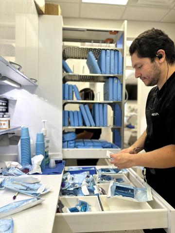 Dental sterile technician sorting and sterilizing dental tools and equipment.
