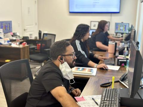 Dental team members sitting at their computers in an office. 