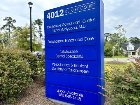 A blue parking lot sign with the names of the practices listed.