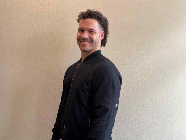 Man smiling in front of wall